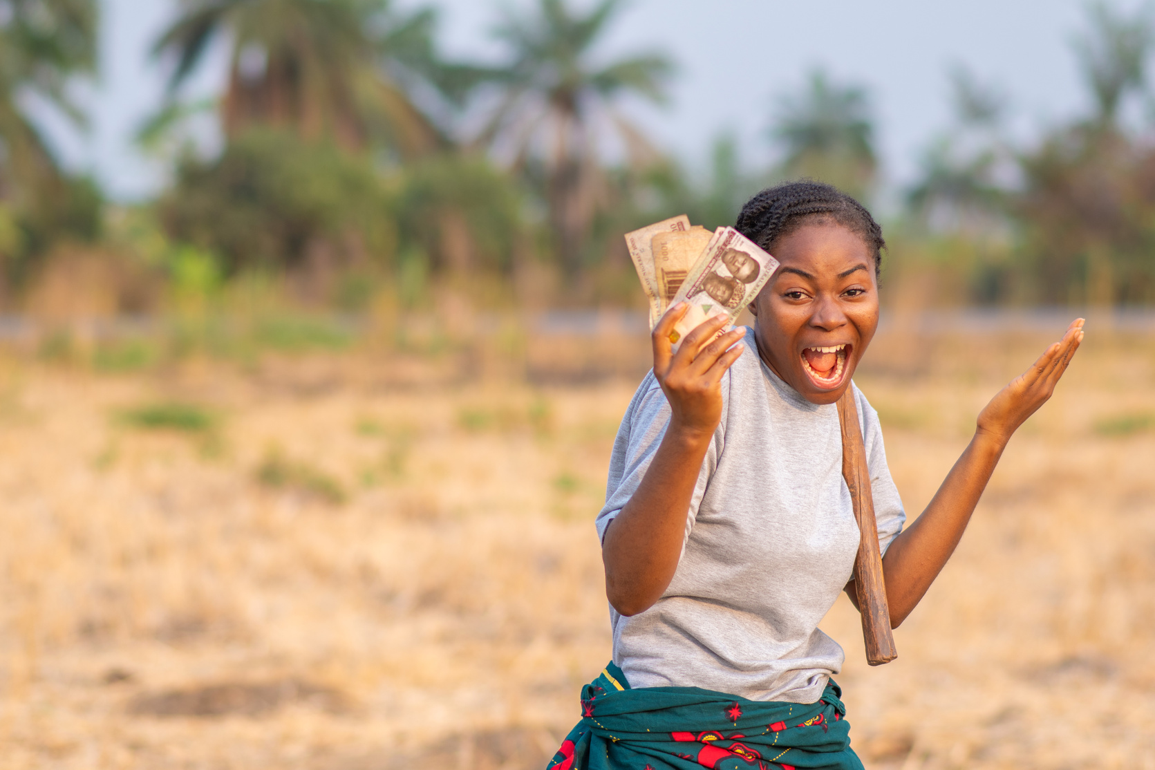 African Farmer Feeling Excited Holding Money in Her Hand